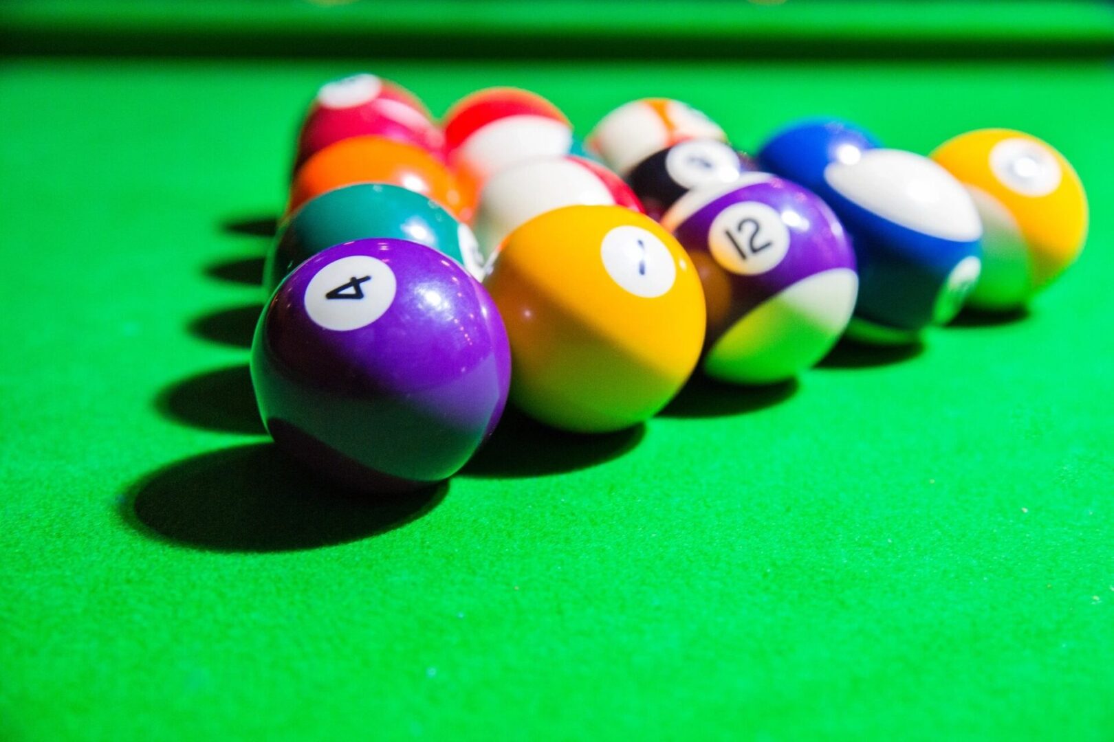 A group of billiard balls on a green table.