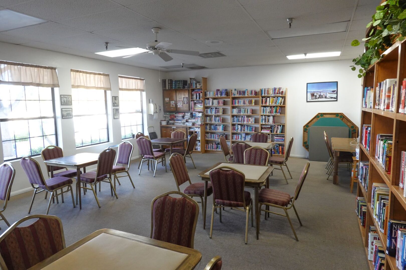 A library with tables and chairs and bookshelves.