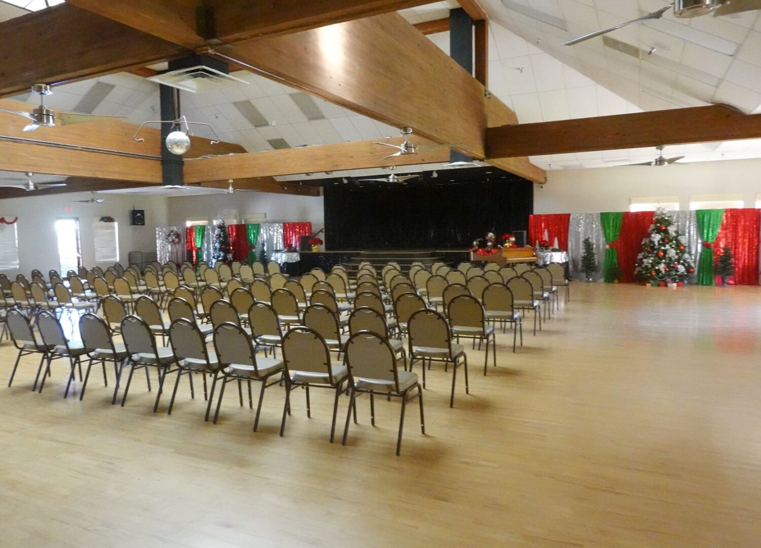A large room filled with chairs and a christmas tree.