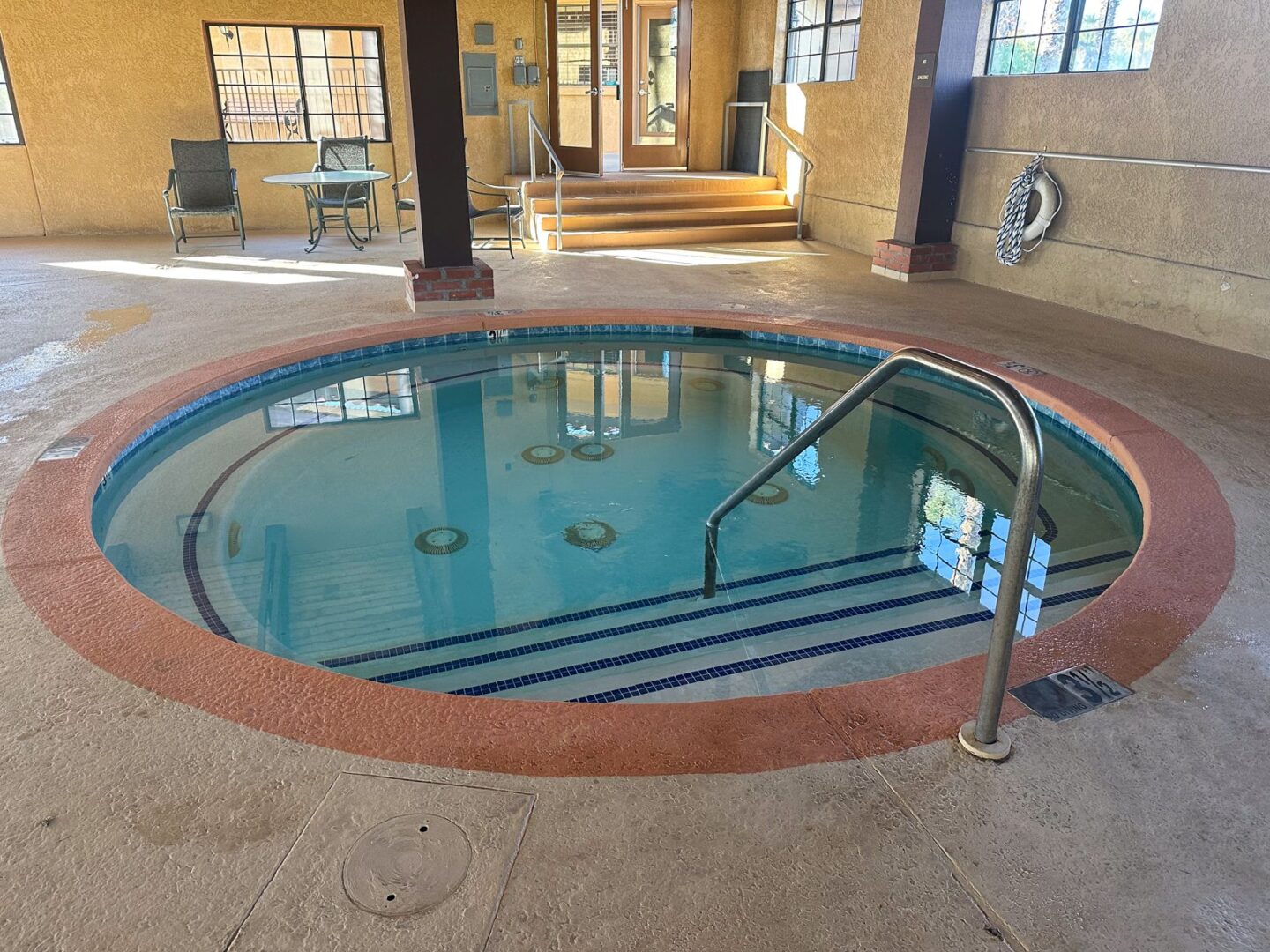 A pool with a hot tub in the middle of a room.